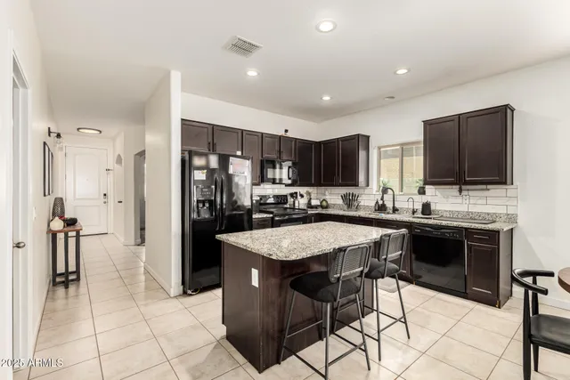 a kitchen with stainless steel appliances kitchen island granite countertop a sink and cabinets