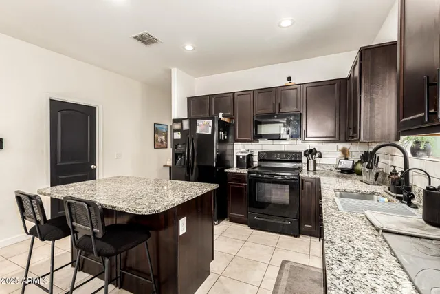 a kitchen with stainless steel appliances granite countertop a stove refrigerator sink and cabinets
