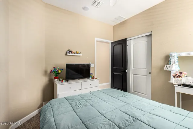 a bedroom with a bed and a flat screen tv