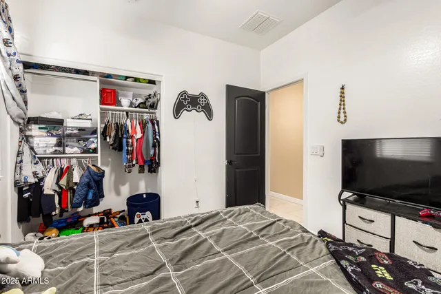 a bedroom with a bed and a flat screen tv