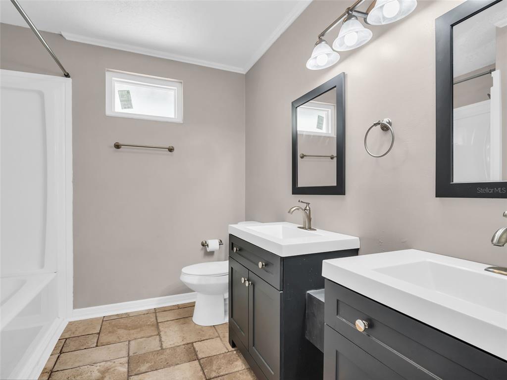 6241 Bayside Drive New Port Richey, FL 34652 - Photo 33 of 78 a bathroom with a toilet a sink a mirror and a window