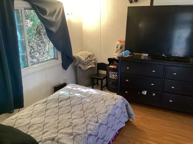 a bedroom with a bed and a flat screen tv