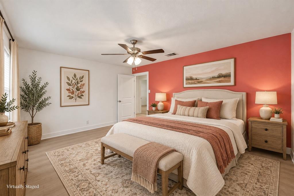 917 Goodwyn Road Italy, TX 76651 - Photo 9 of 40 Wood-finish flooring, ceiling fan, and white walls with a vibrant accent wall