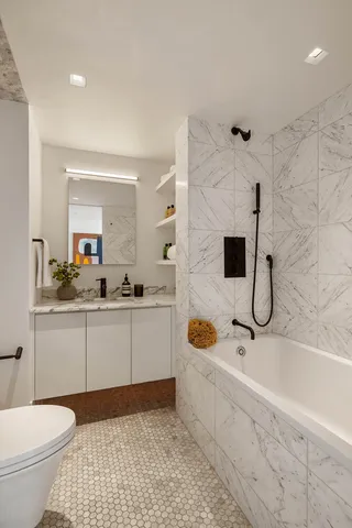a bathroom with a sink a toilet and shower