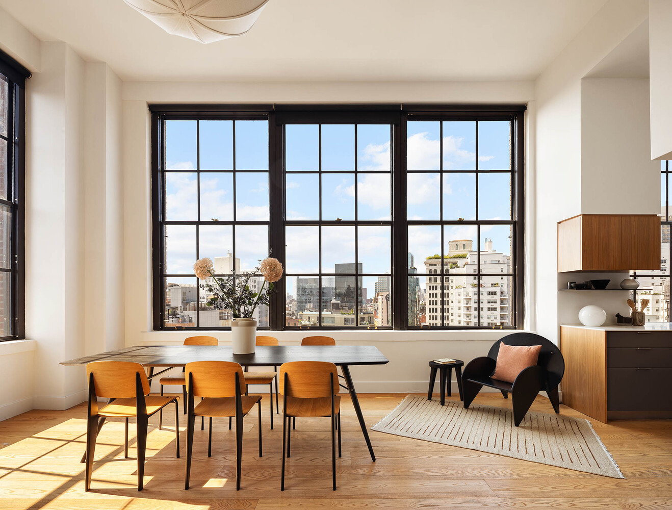 a dining room with furniture and large windows