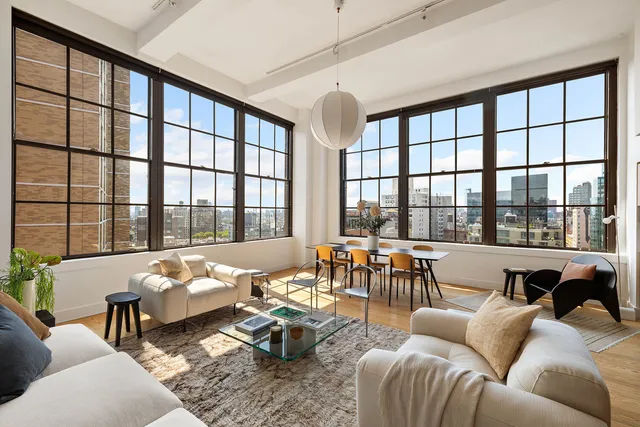 a living room with a table and chair with window