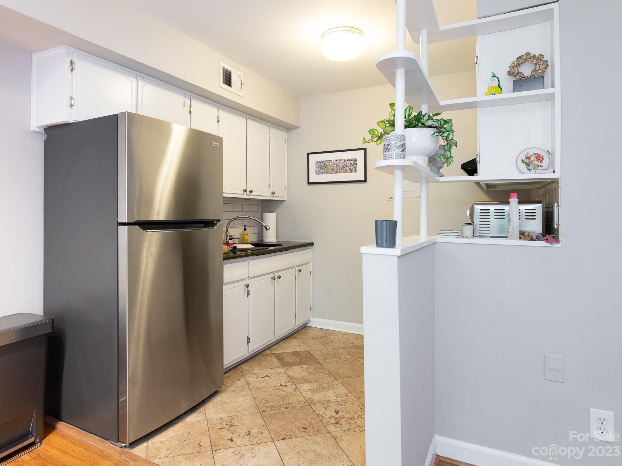 400 Queens Road, Unit C6 Charlotte, NC 28207 - Photo 16 of 25 a kitchen with stainless steel appliances a refrigerator sink and cabinets