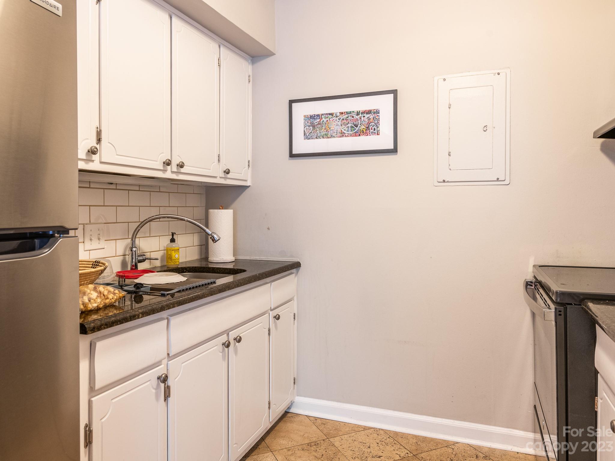 400 Queens Road, Unit C6 Charlotte, NC 28207 - Photo 24 of 25 a kitchen with a white cabinets and a stove