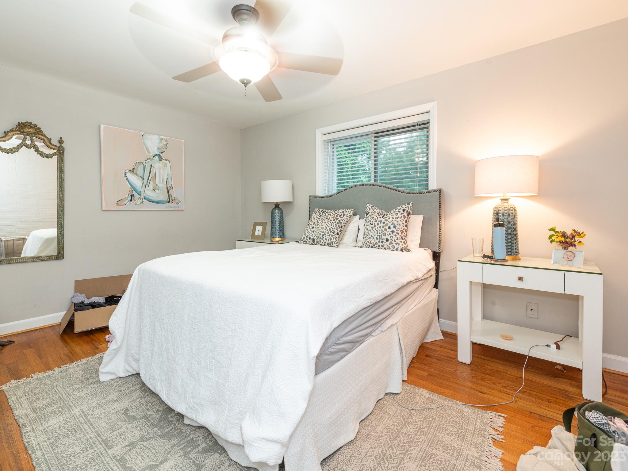 400 Queens Road, Unit C6 Charlotte, NC 28207 - Photo 5 of 25 a spacious bedroom with a bed and a lamp on dresser