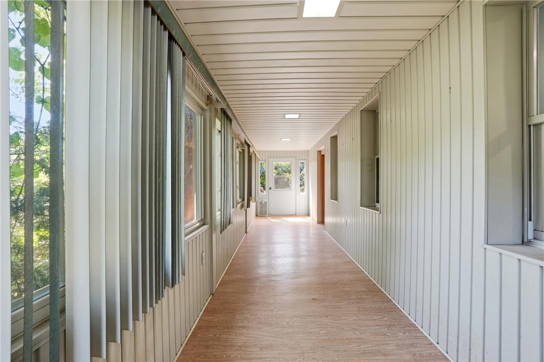 6271 Batman Road Zionsville, PA 18092 - Photo 47 of 100 A long, bright corridor with ample window light and durable flooring, leading to an inviting outdoor space.