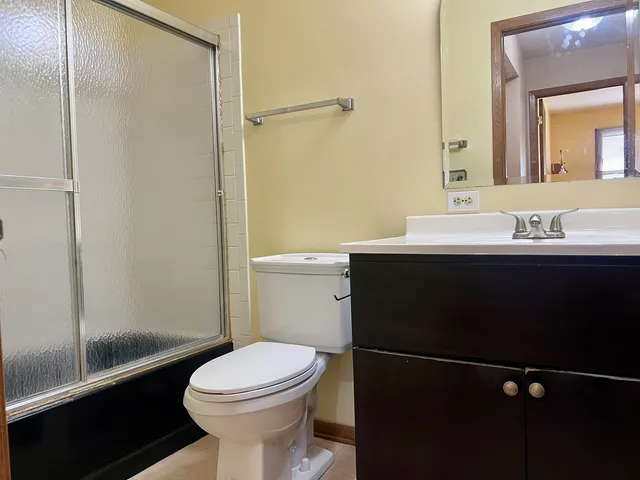 a bathroom with a sink a toilet a mirror and shower