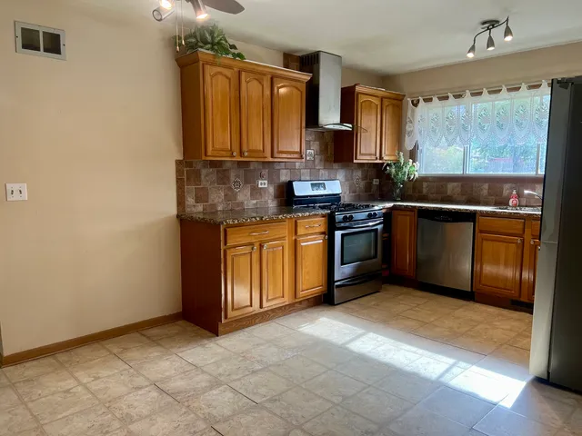 a kitchen with stainless steel appliances granite countertop a stove sink and cabinets