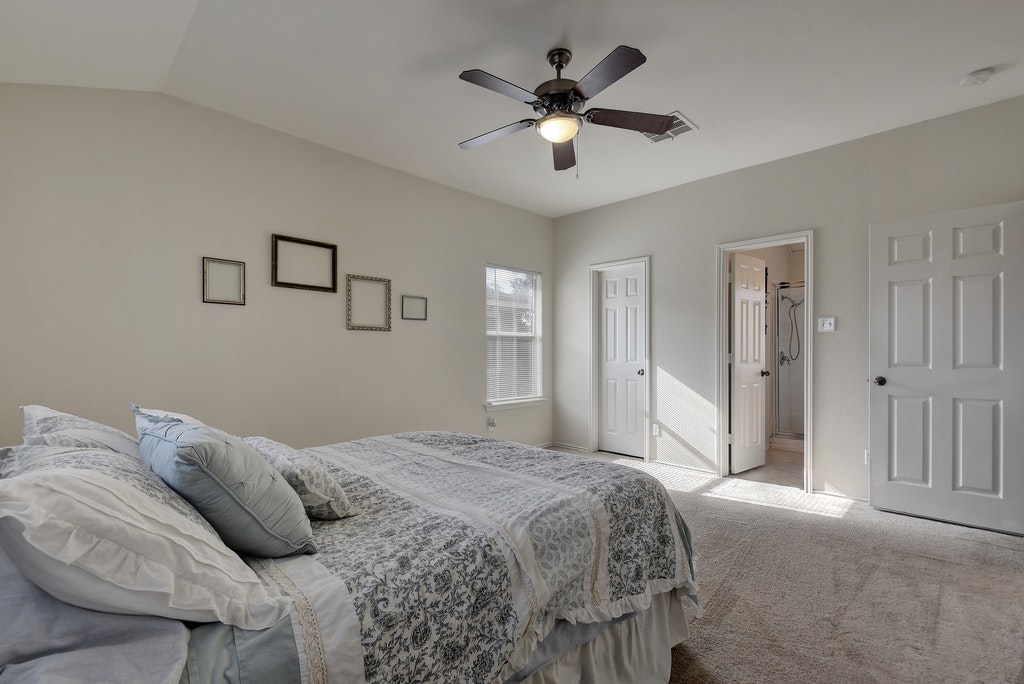 2201 Keepsake Drive Austin, TX 78745 - Photo 13 of 25 a bedroom with a large bed and a chandelier