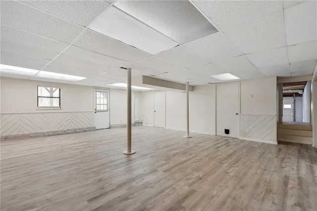 a view of an empty room with window and wooden floor