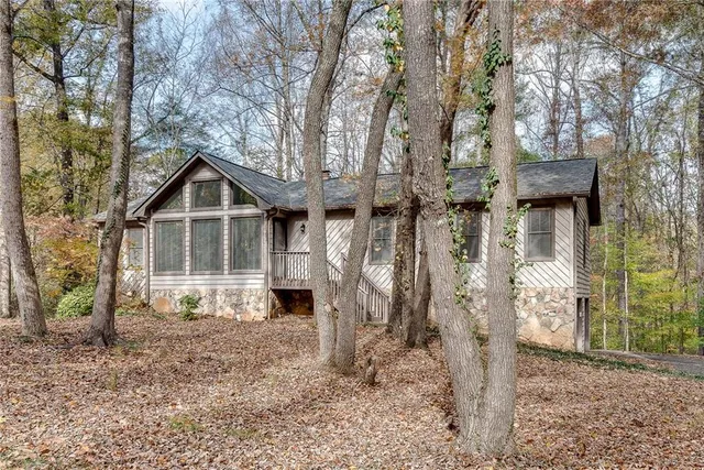 a view of a house with a yard and large tree