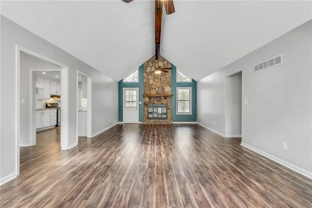 a view of a room with wooden floor staircase and a kitchen space