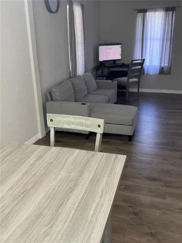 a living room with furniture and a wooden floor