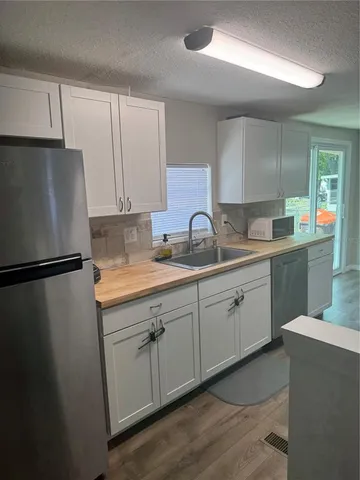 a kitchen with a sink a refrigerator and cabinets
