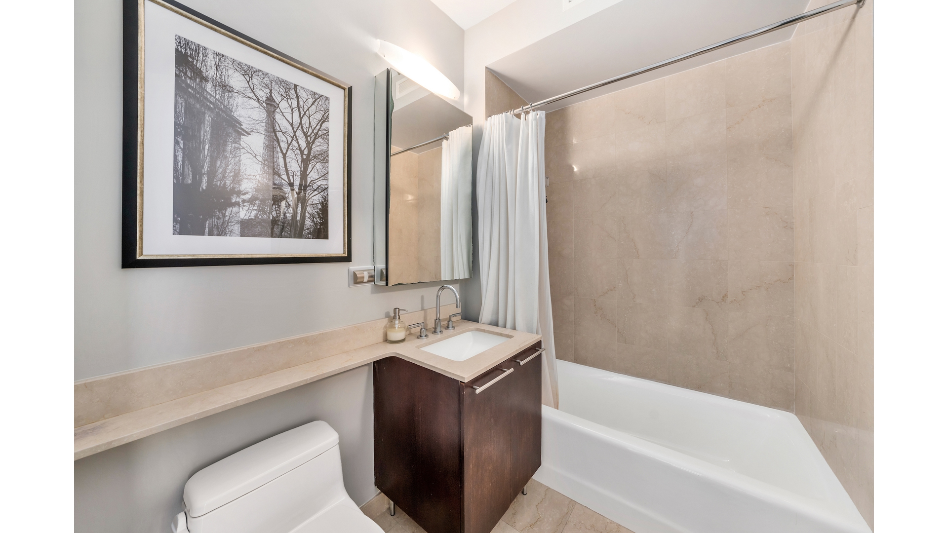 230 West 56th Street, Unit 54F Manhattan, NY 10019 - Photo 10 of 12 a bathroom with a granite countertop sink a toilet and a bathtub