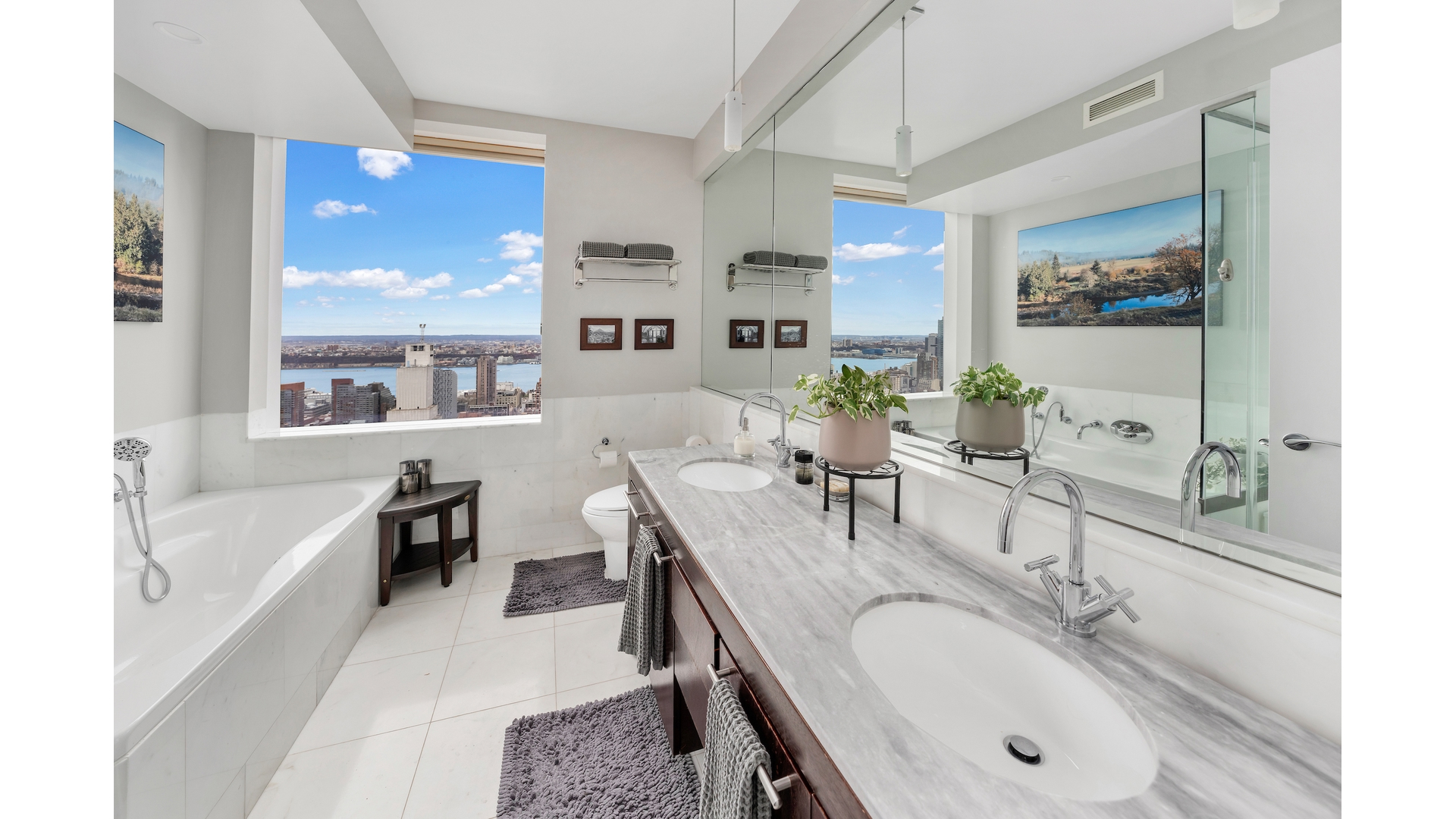 230 West 56th Street, Unit 54F Manhattan, NY 10019 - Photo 8 of 12 a en suite bathroom with a granite countertop tub sink and mirror