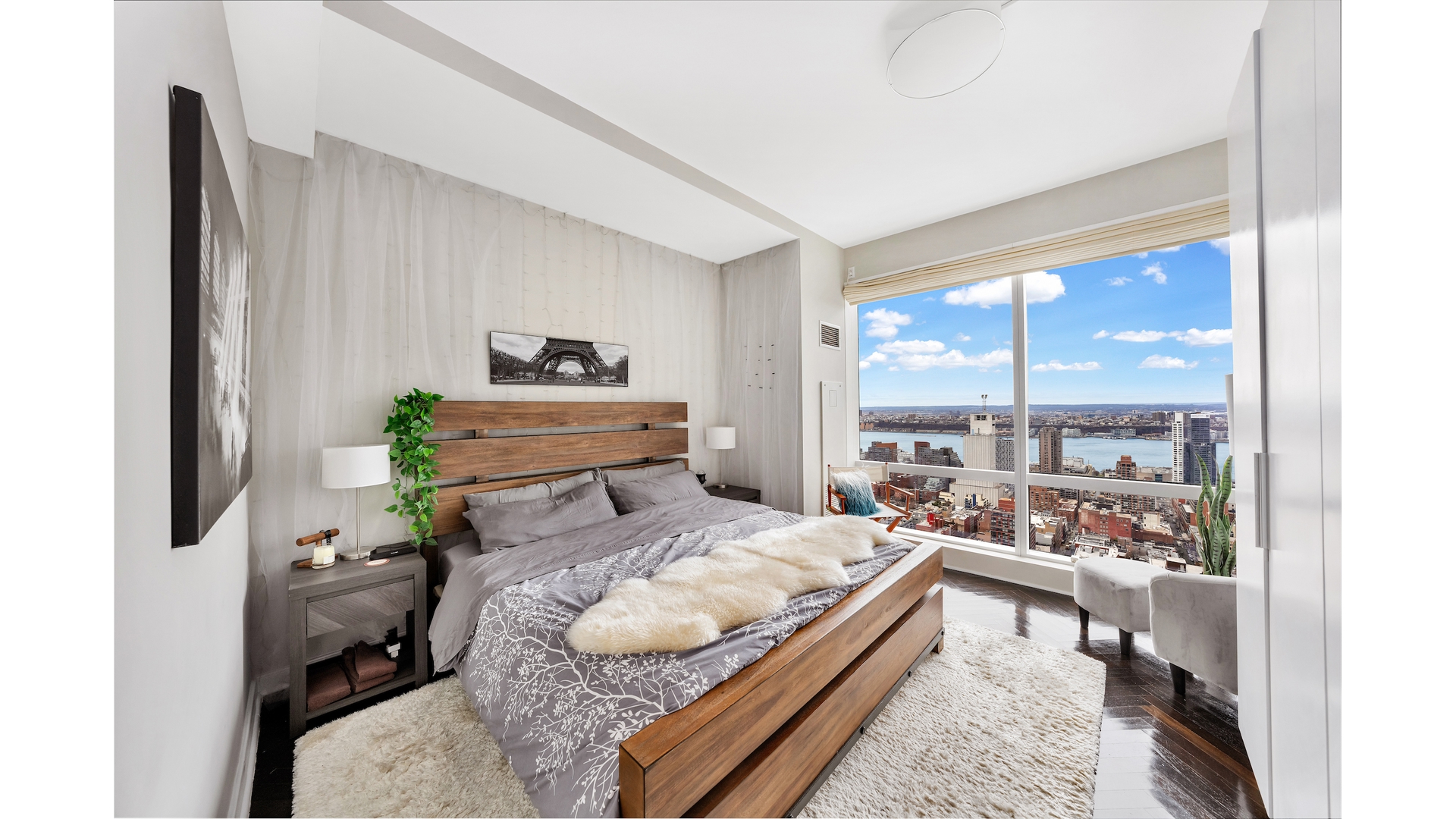 230 West 56th Street, Unit 54F Manhattan, NY 10019 - Photo 9 of 12 a bed room with furniture and a large window
