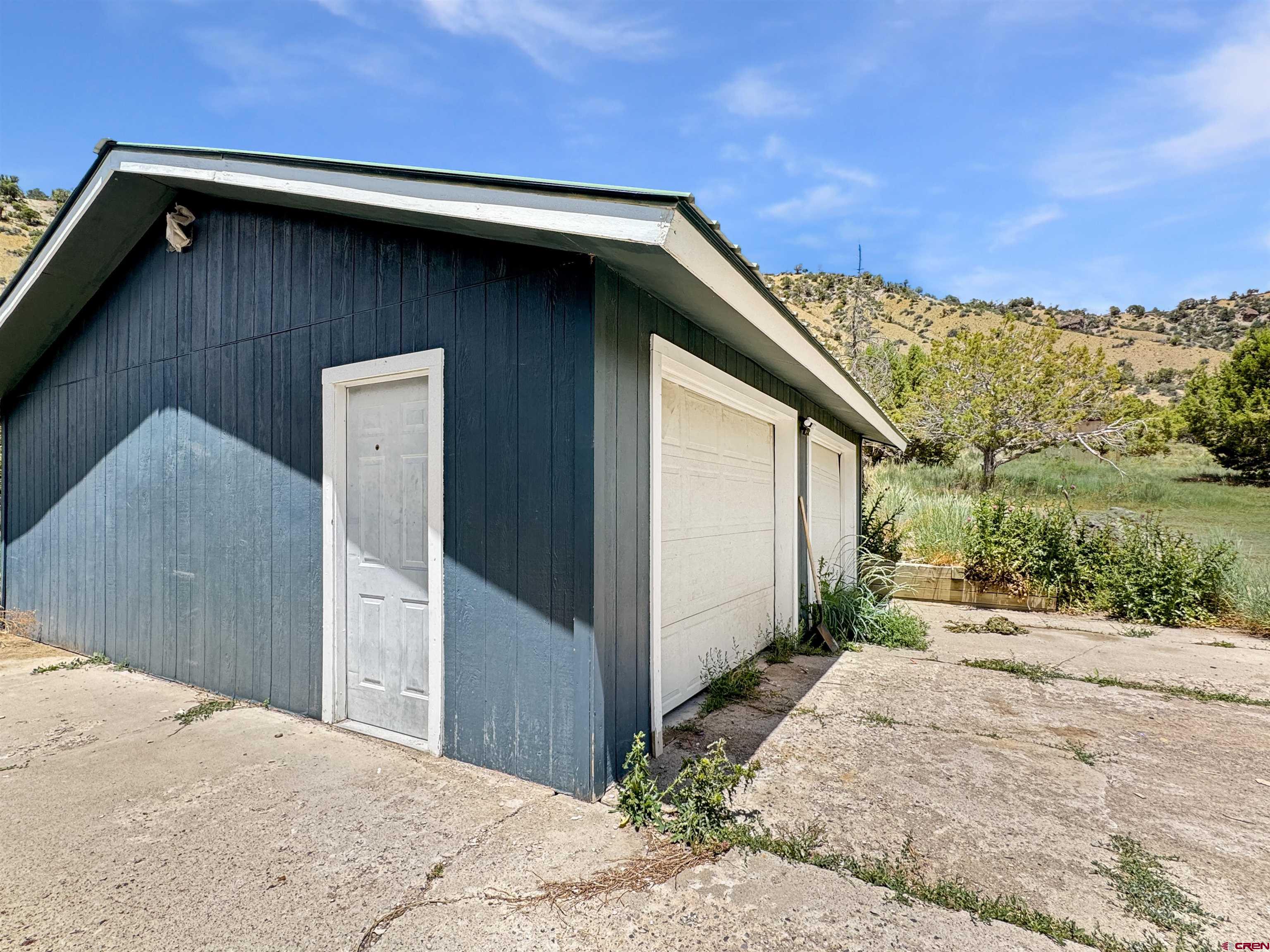 43157 Long Gulch Road Crawford, CO 81415 - Photo 27 of 35 a backyard of a house with a yard and garage