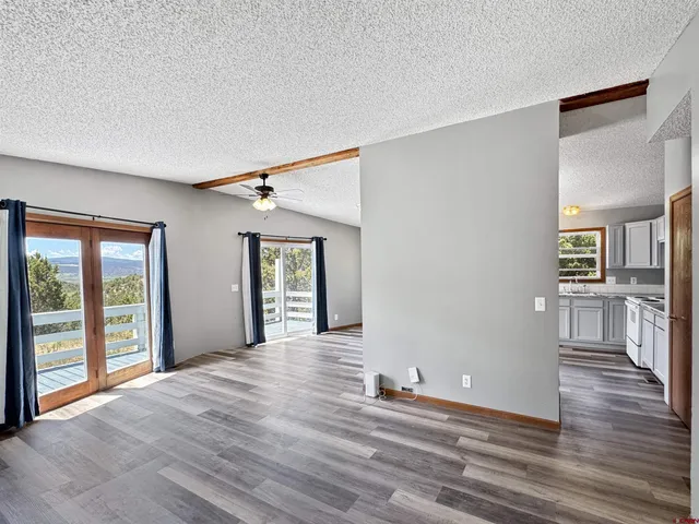 a view of a big room with wooden floor and windows