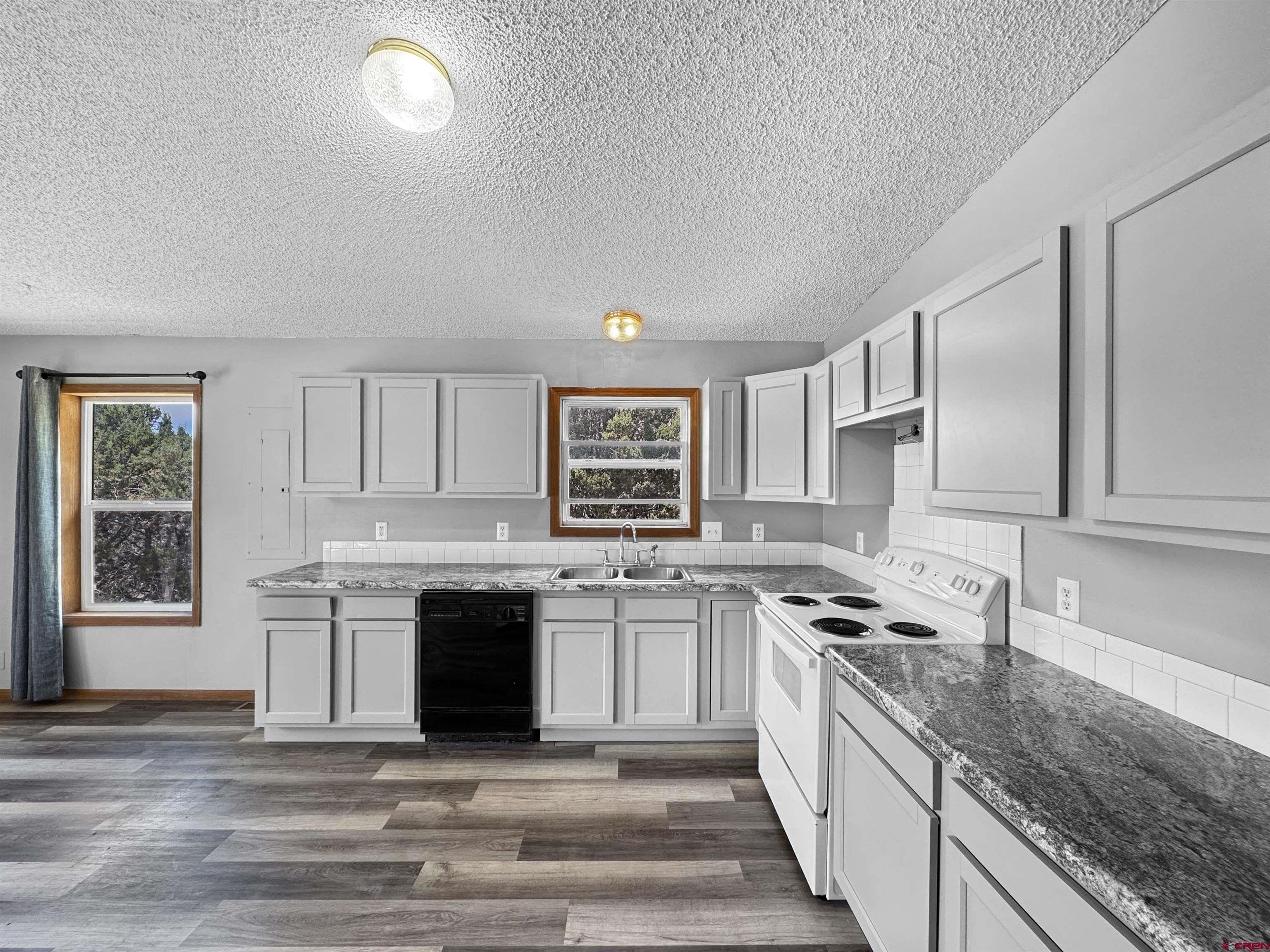 43157 Long Gulch Road Crawford, CO 81415 - Photo 3 of 35 a large kitchen with granite countertop a stove top oven sink and cabinets