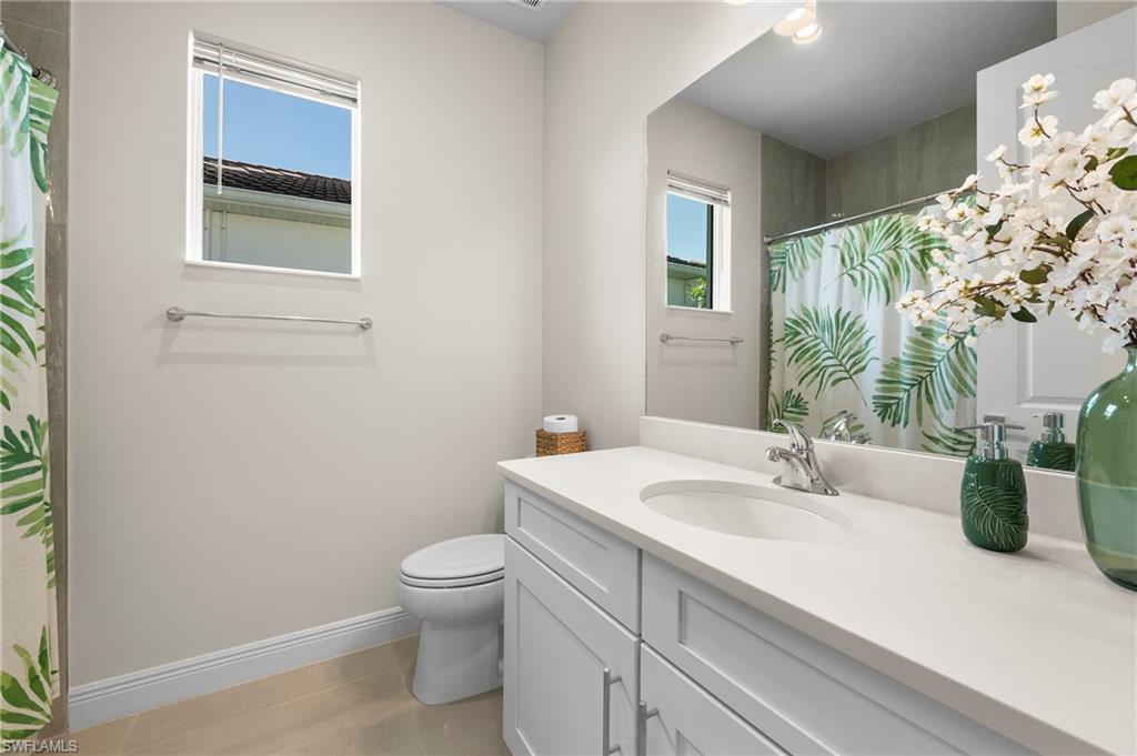 8897 Redonda Drive Naples, FL 34114 - Photo 24 of 42 a bathroom with a sink a toilet and a mirror