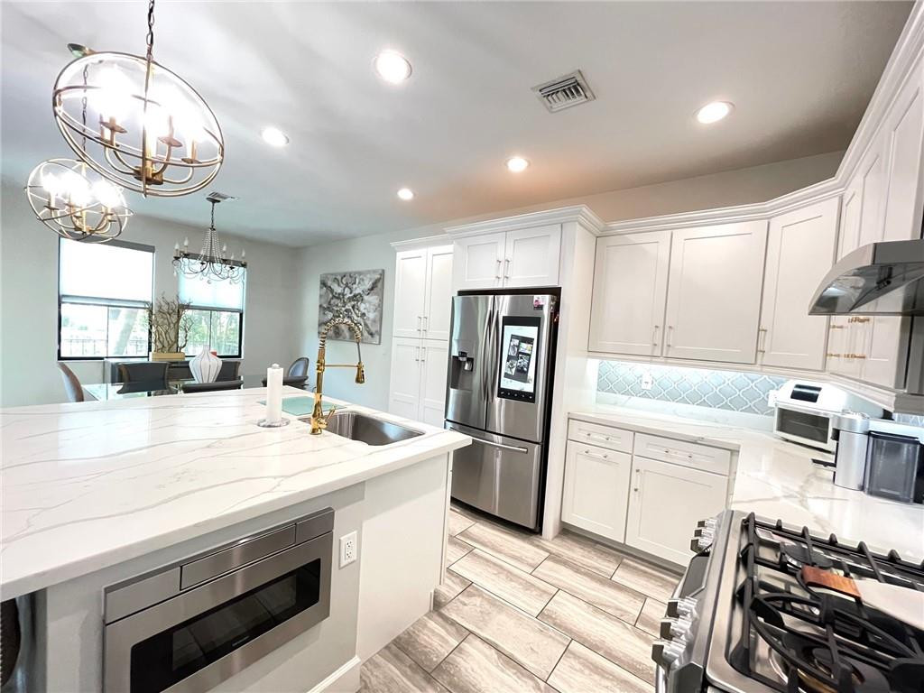 Undisclosed Address Sunrise, FL 33323 - Photo 11 of 88 a kitchen with stainless steel appliances granite countertop a stove and a refrigerator