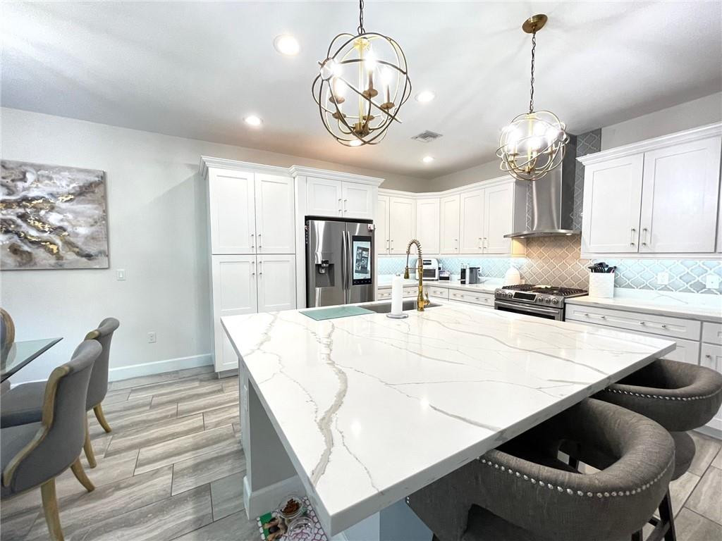 Undisclosed Address Sunrise, FL 33323 - Photo 14 of 88 a kitchen with stainless steel appliances granite countertop a stove a refrigerator a sink a dining table and chairs with wooden floor