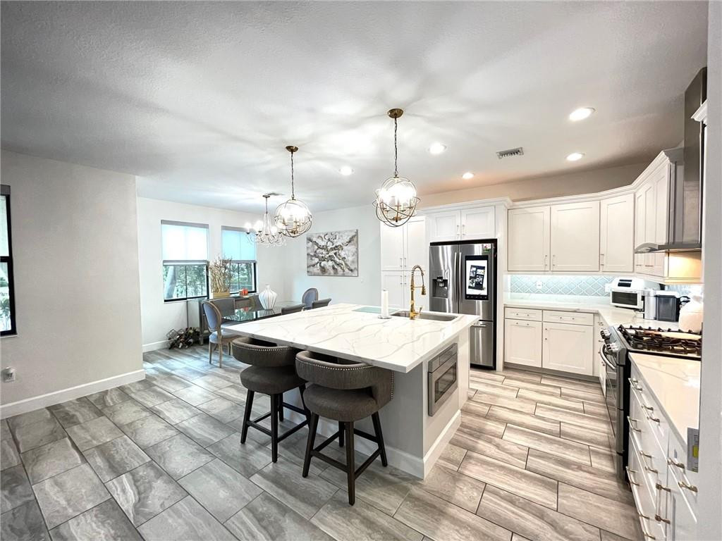 Undisclosed Address Sunrise, FL 33323 - Photo 19 of 88 a kitchen with a table chairs refrigerator and microwave