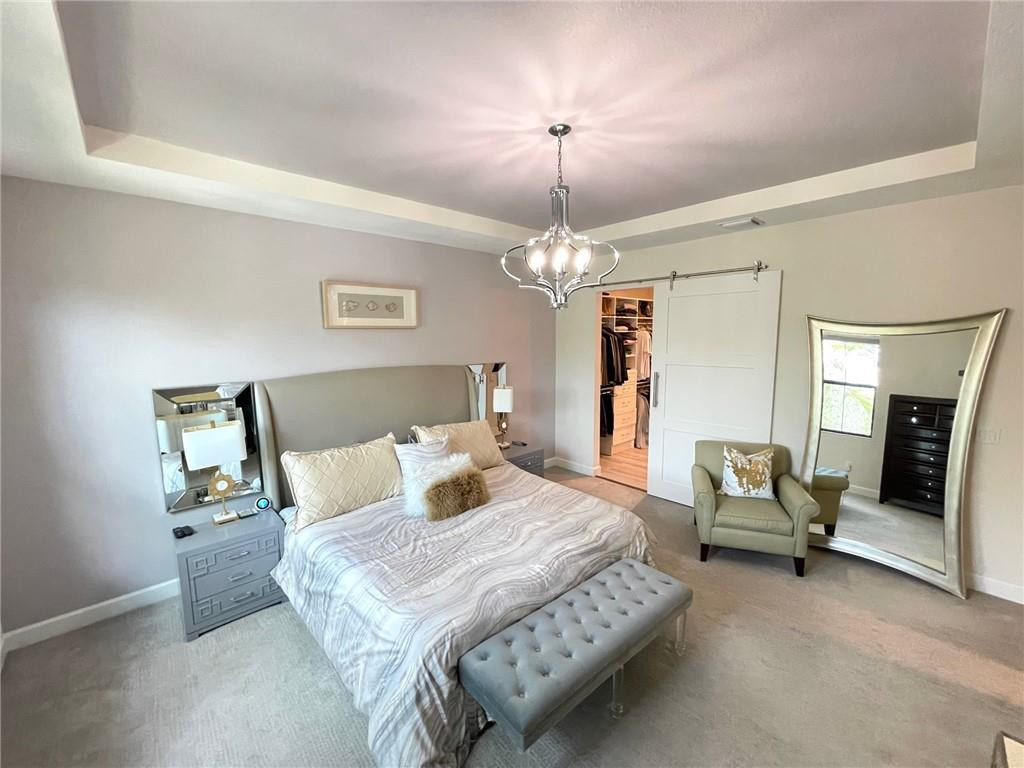 Undisclosed Address Sunrise, FL 33323 - Photo 33 of 88 a bedroom with a bed and a chandelier