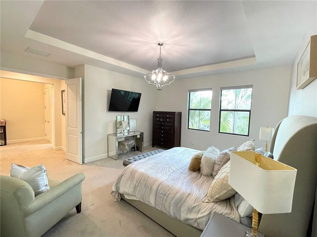 Undisclosed Address Sunrise, FL 33323 - Photo 37 of 88 a spacious bedroom with a bed a couch and a flat screen tv