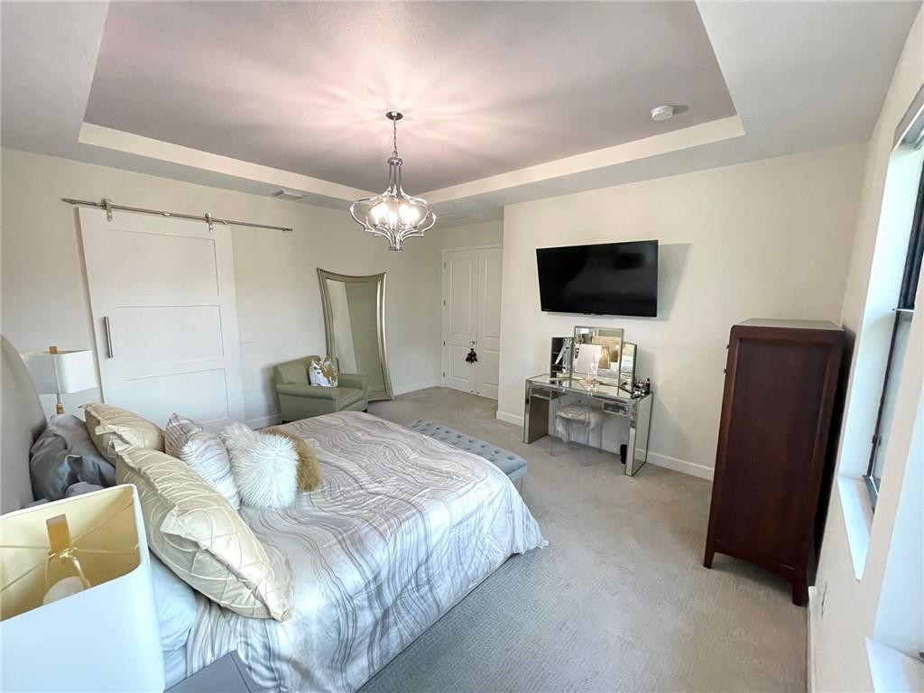 Undisclosed Address Sunrise, FL 33323 - Photo 40 of 88 a spacious bedroom with a bed and a flat screen tv