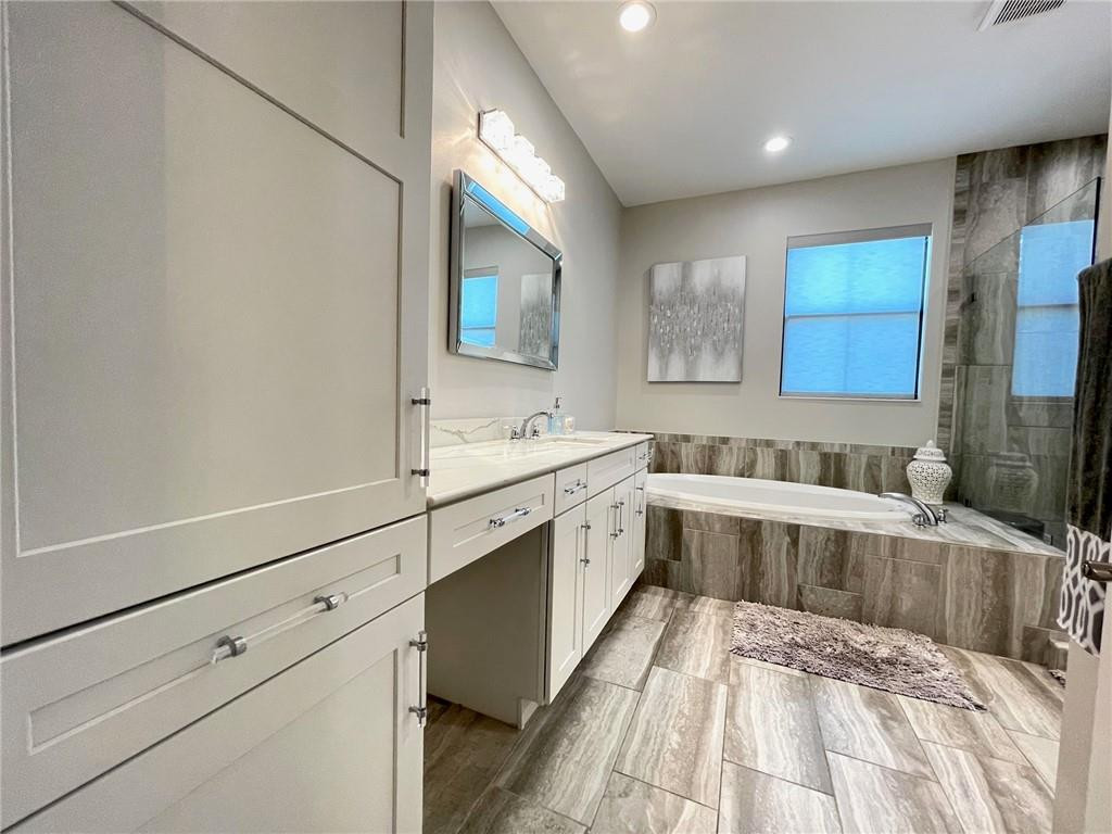 Undisclosed Address Sunrise, FL 33323 - Photo 47 of 88 a spacious bathroom with a double vanity sink a mirror and a bathtub