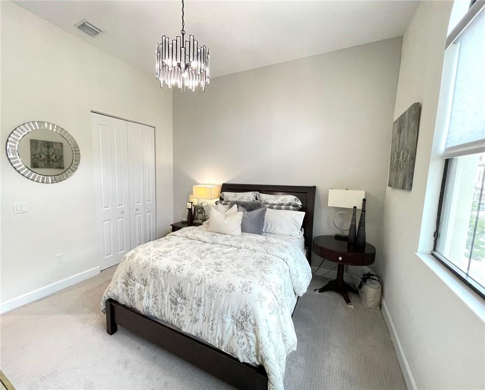 Undisclosed Address Sunrise, FL 33323 - Photo 71 of 88 a bedroom with a bed and a chandelier