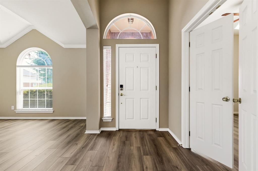 2210 High Point Drive Sachse, TX 75048 - Photo 2 of 23 an empty room with wooden floor mirror and windows