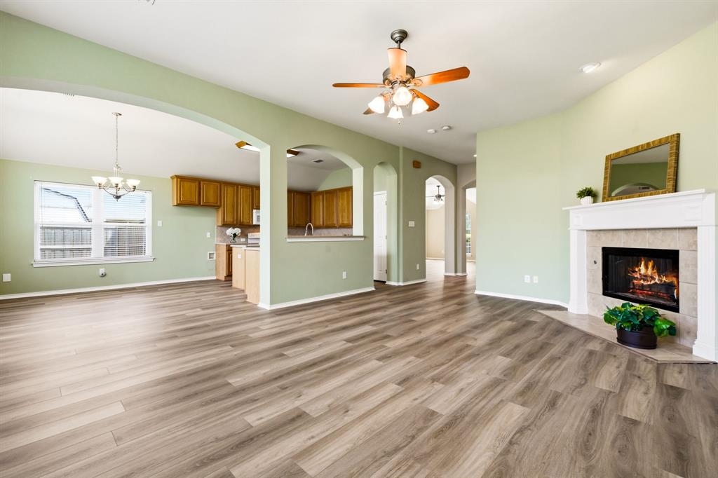 2210 High Point Drive Sachse, TX 75048 - Photo 8 of 23 a view of an empty room with wooden floor and a kitchen