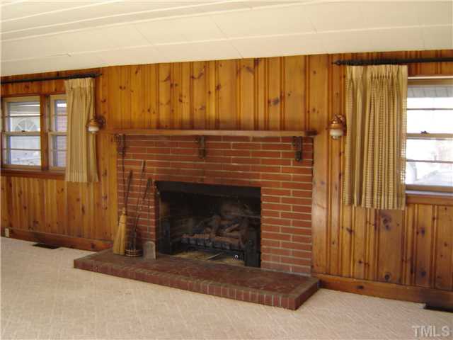 815 Goodwin Road Durham, NC 27712 - Photo 6 of 15 a view of an empty room with wooden floor and a fireplace