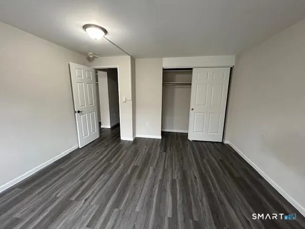 an empty room with wooden floor and closet
