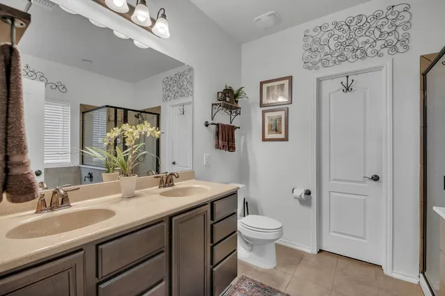 a bathroom with a double vanity sink a toilet and a mirror