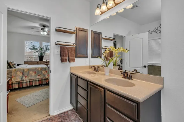 a en suite bathroom with a sink double vanity granite and a mirror