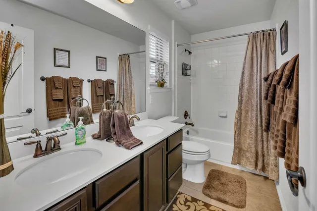 a bathroom with a double vanity sink toilet and shower