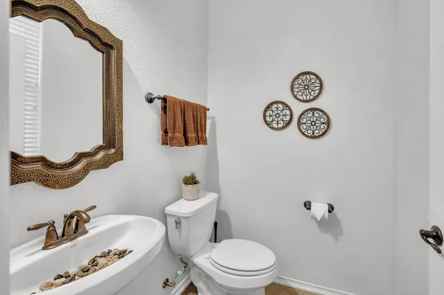 a white toilet sitting next to a bathroom sink