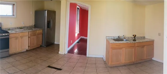 a utility room with granite countertop cabinets and sink