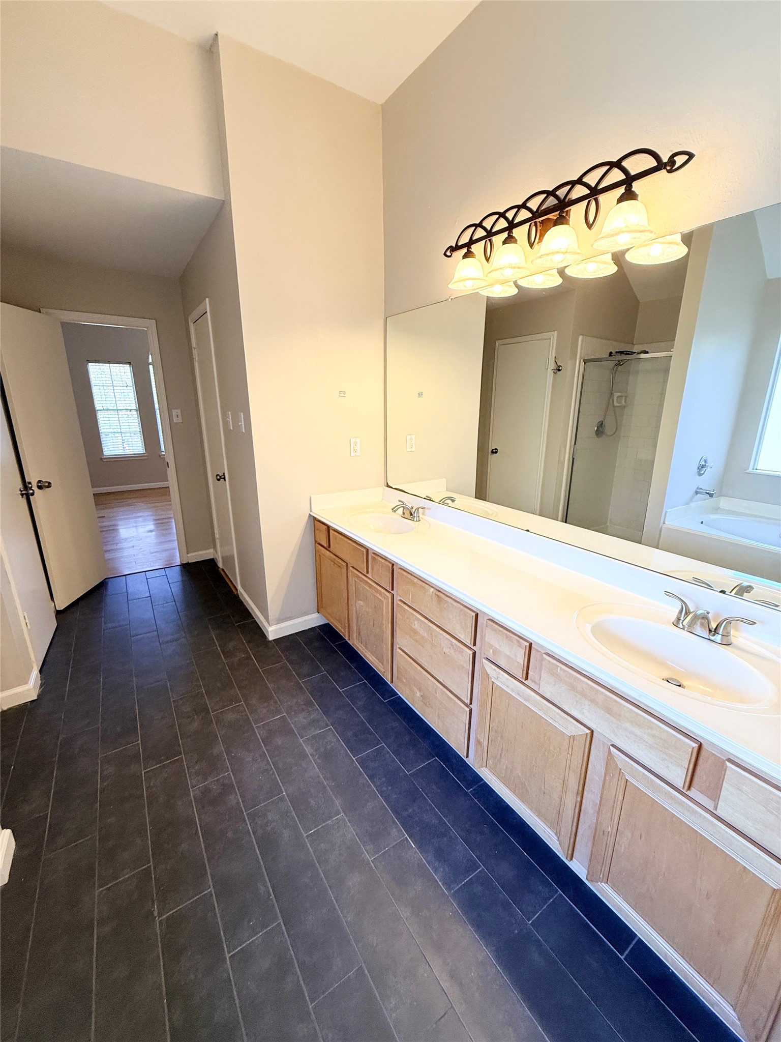 245 North Ranch House Road Angleton, TX 77515 - Photo 12 of 19 This primary bathroom is bright and modern, featuring a stylish vanity, elegant tile details, and plenty of natural light.
