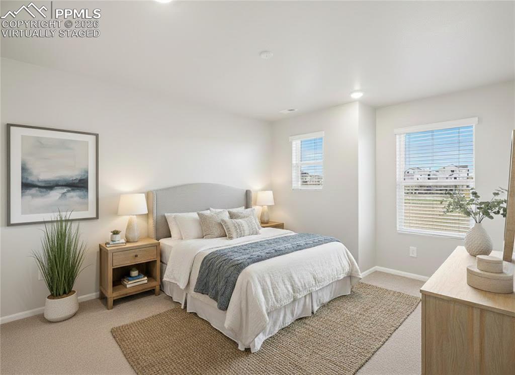 6754 Roundtail Way Colorado Springs, CO 80925 - Photo 15 of 31 a bedroom with a bed a table and chair