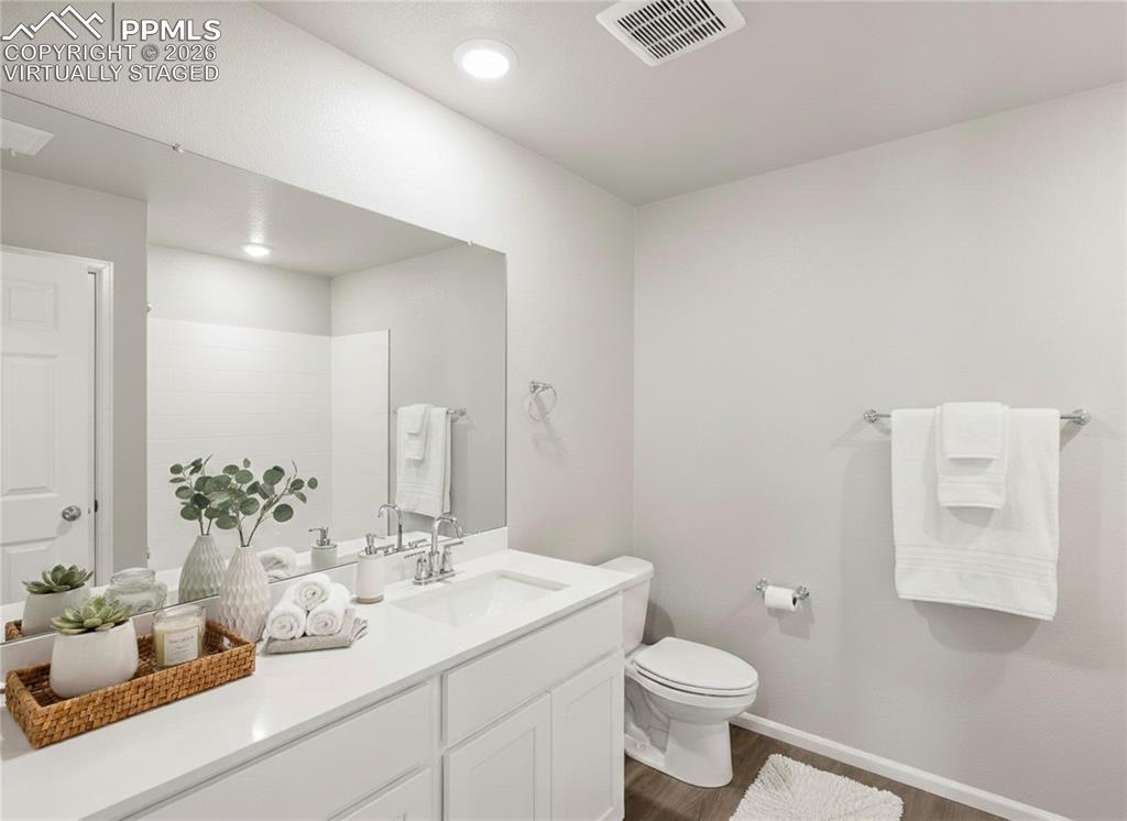 6754 Roundtail Way Colorado Springs, CO 80925 - Photo 19 of 31 a bathroom with a toilet sink and mirror