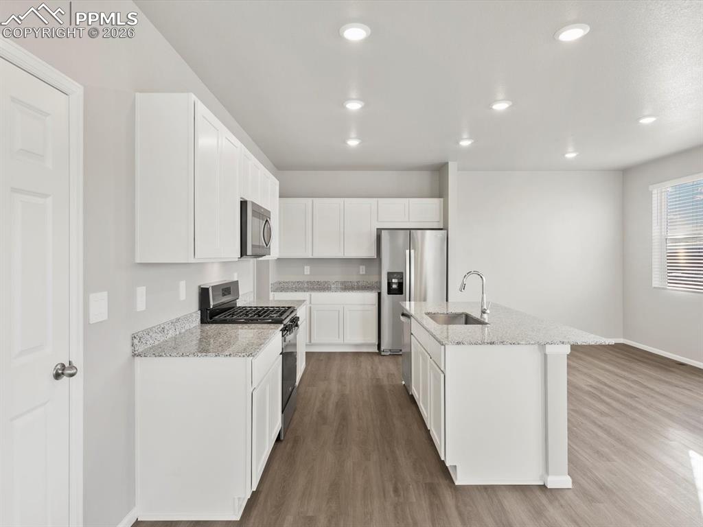6754 Roundtail Way Colorado Springs, CO 80925 - Photo 26 of 31 a kitchen with stainless steel appliances a sink stove and cabinets